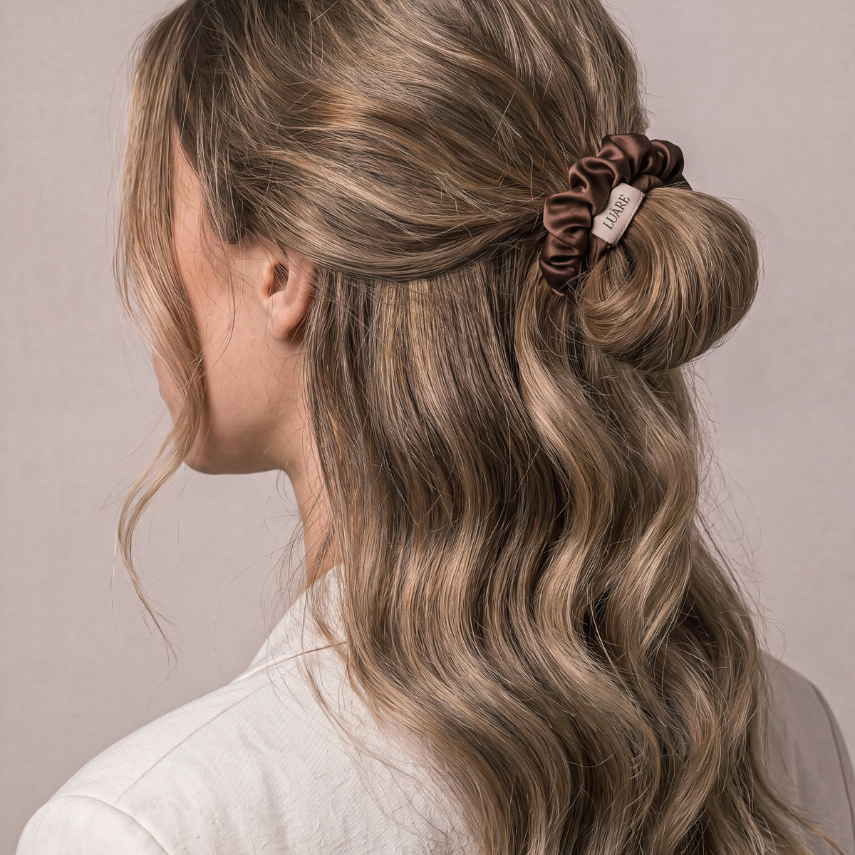 Scrunchie de seda nougat de Luãre recogiendo el pelo sin marcarlo.
