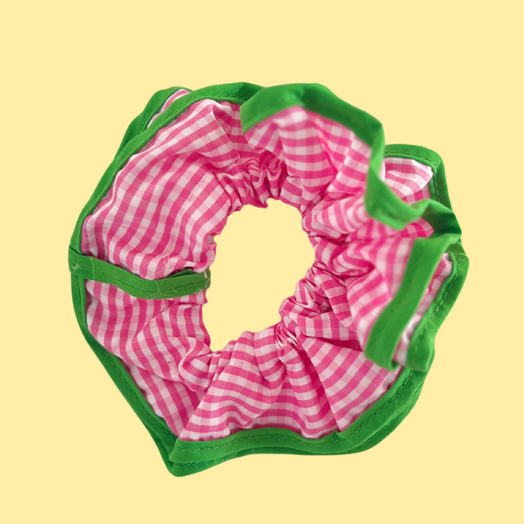 Scrunchie para coletas estilosas y looks vibrantes. Coletero de La Crème Organics con cuadros fucsias y remates en verde.