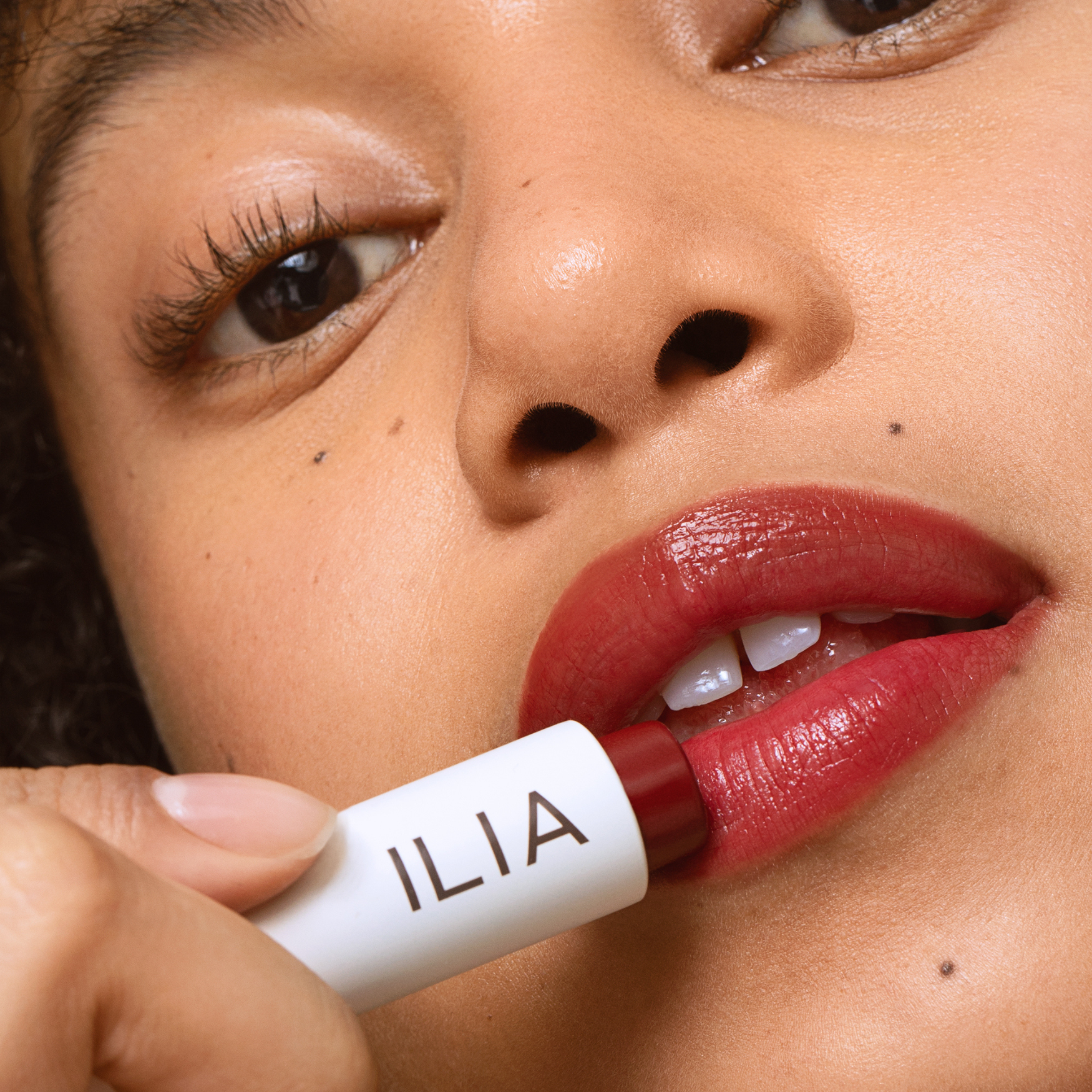 Bálsamo labial Balmy Tint de ILIA Beauty en tono Wanderlust sobre los labios. Color modulable con textura fundente.