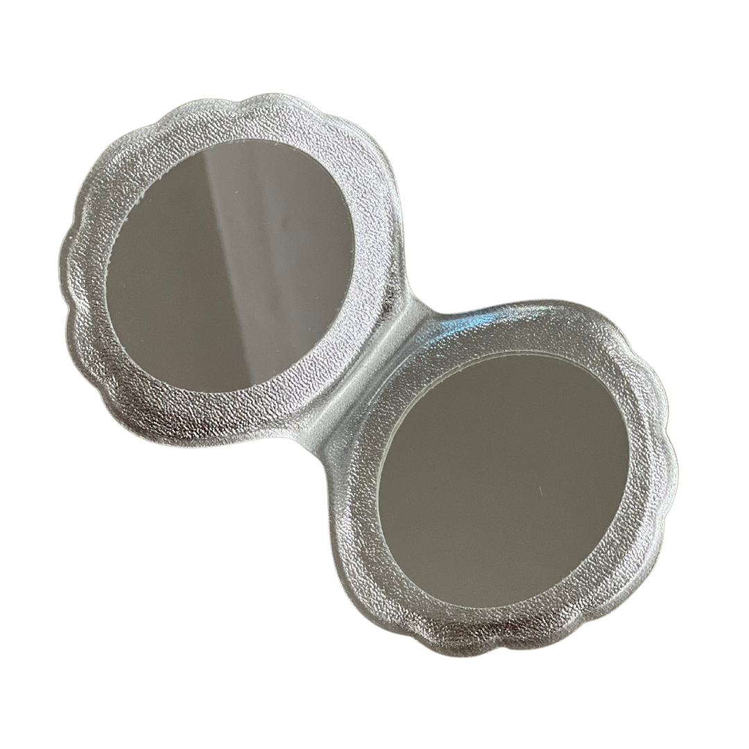 Interior del espejo concha de La Crème: dos caras, una normal y otra con aumento.