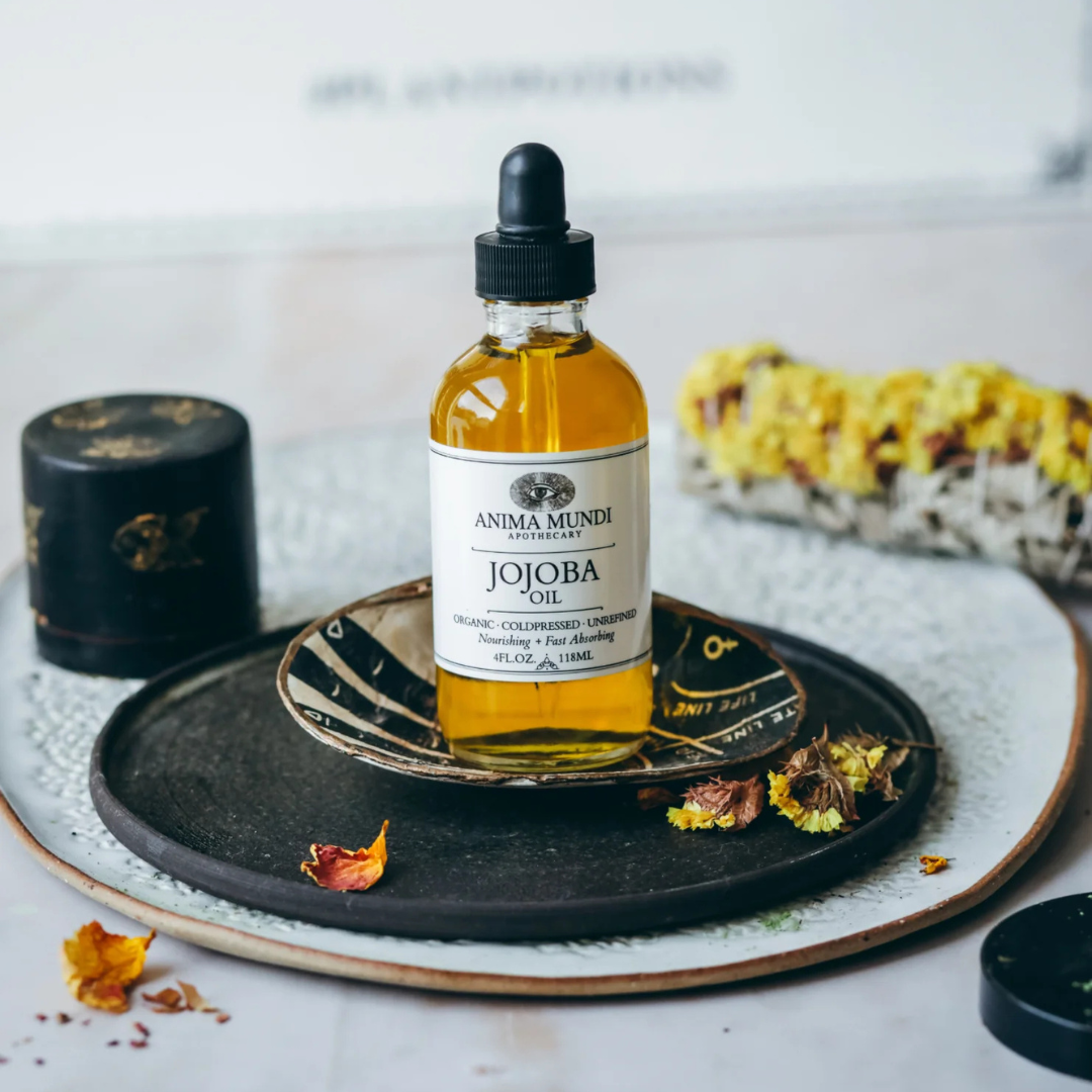Jojoba Oil de Anima Mundi sobre plato decorativo. Aceite versátil para piel y cabello con estructura similar al sebo natural.