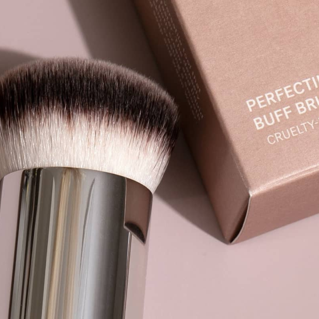 Detalle de perfecting Buff Brush de ILIA Beauty junto a su caja. Herramienta ideal para difuminar con control y cobertura modulable.