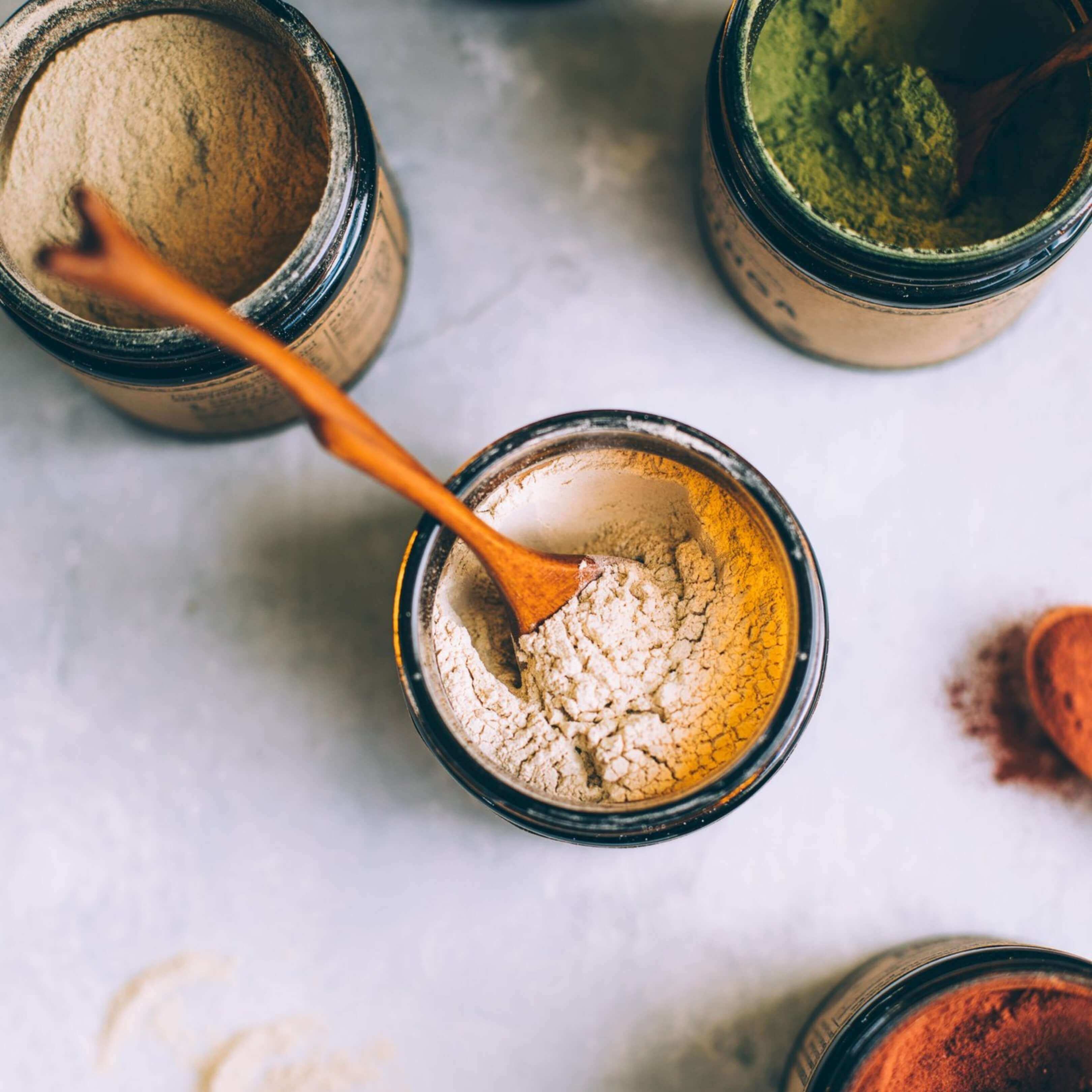 Ashwagandha abierta junto a otros polvos de Anima Mundi. Escena de ritual adaptógeno para reconectar con lo esencial.