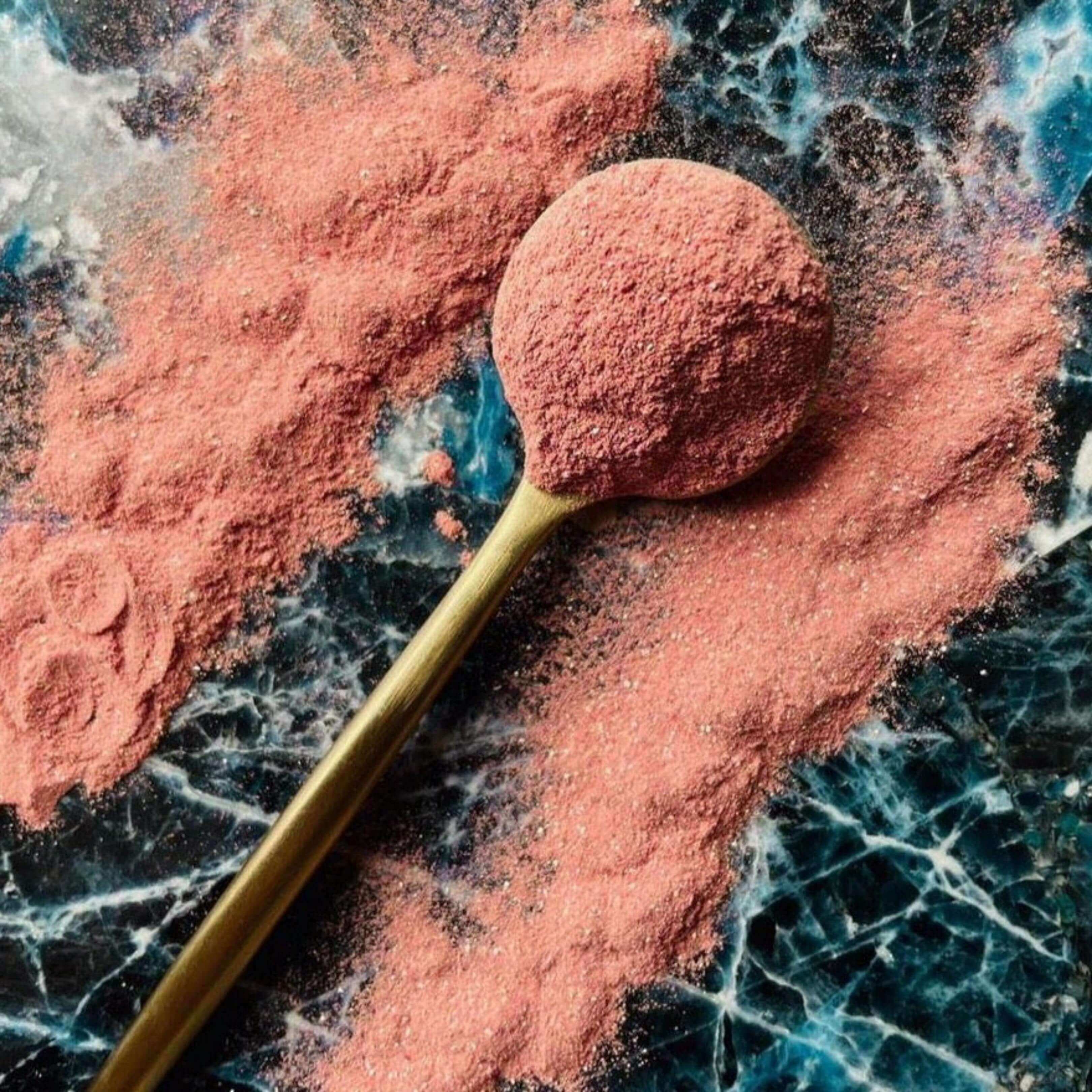 Cucharilla colmada de Belly Love Powder con polvo esparcido. Fórmula herbal para digestión fluida y sensación de ligereza.