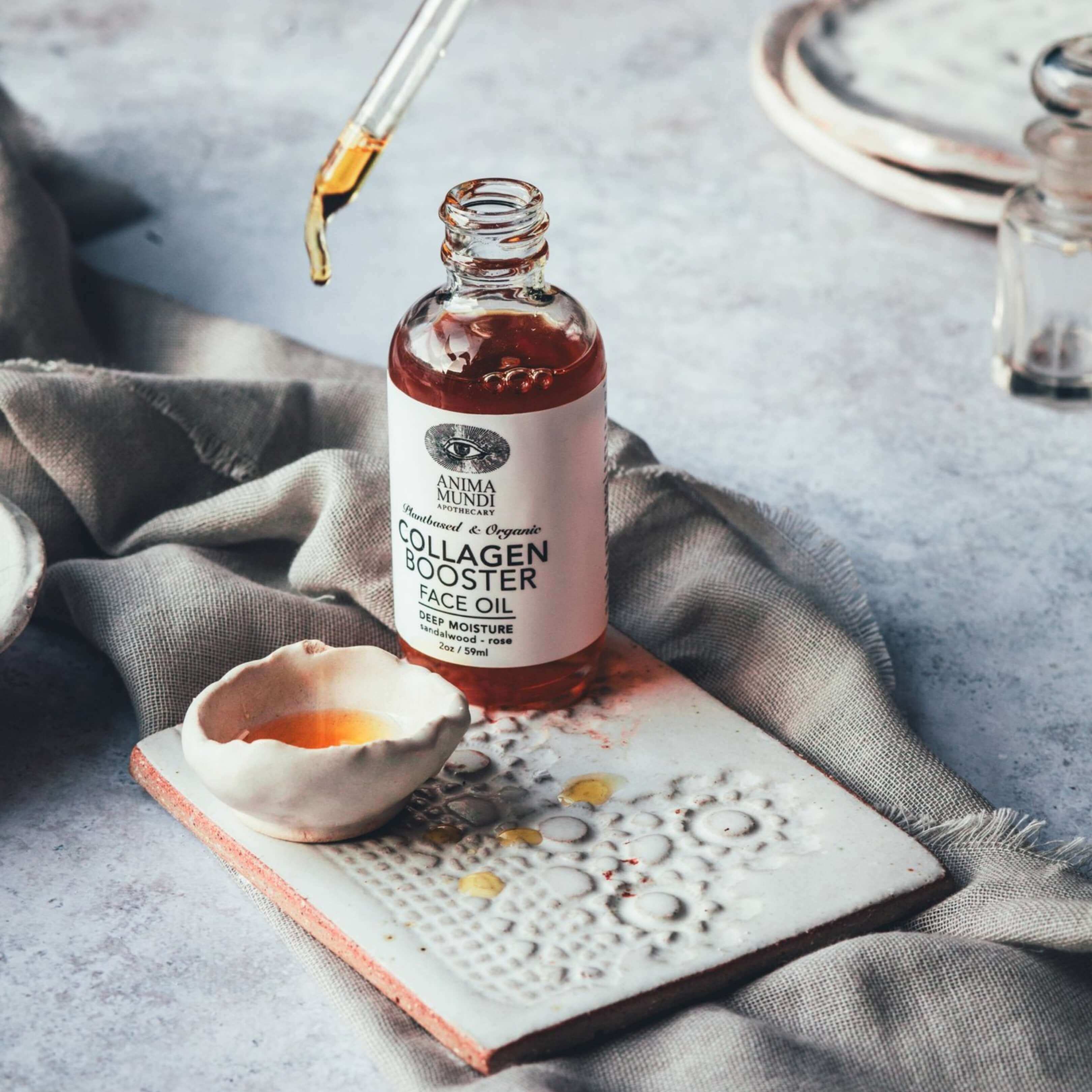 Botanical Collagen Facial Oil vertido en bol. Aceite sensorial con rosa y sándalo para pieles que buscan luz y regeneración.