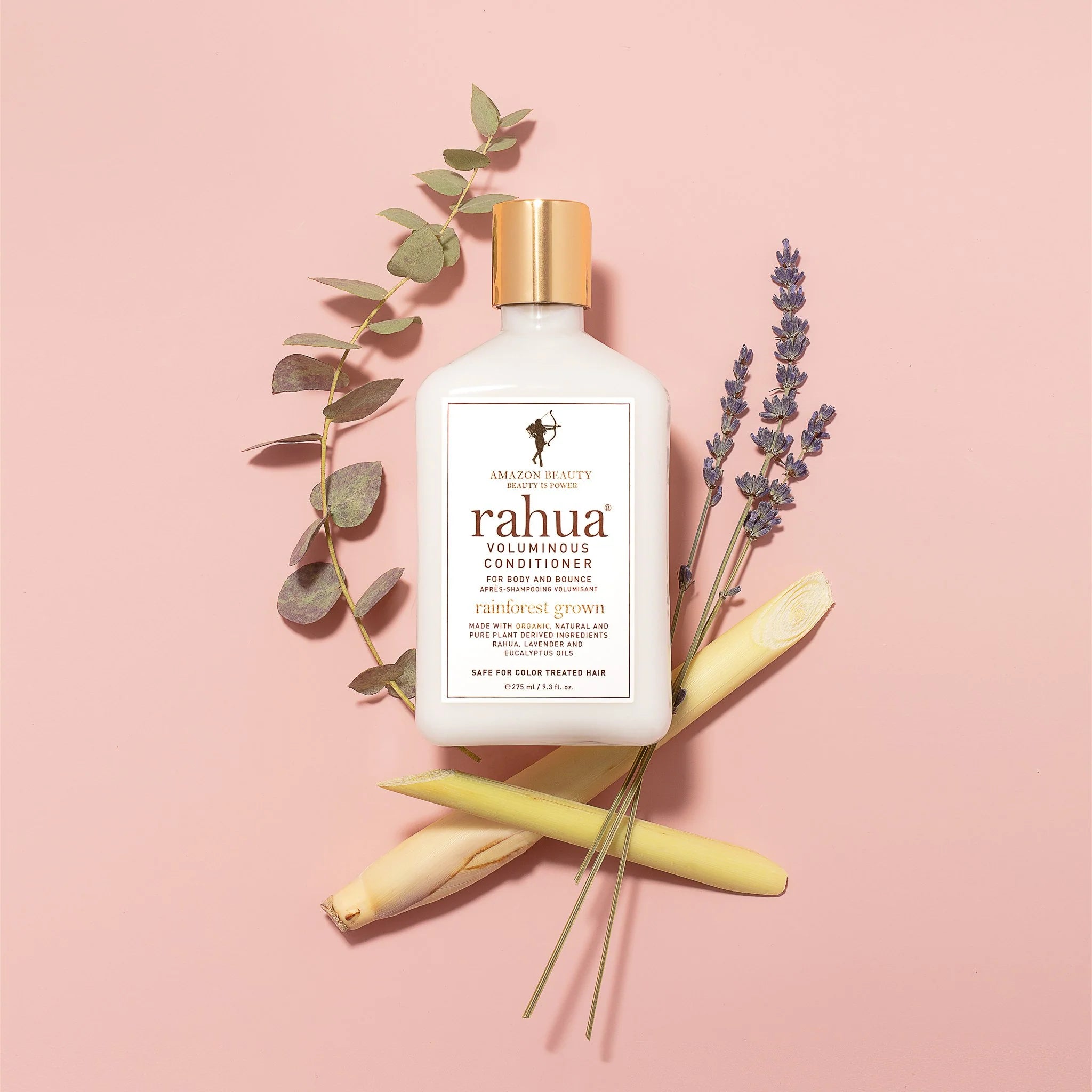 Rahua Voluminous Conditioner. Acondicionador Rahua rodeado de flores. Fórmula suavizante e hidratante, textura ligera y brillo.
