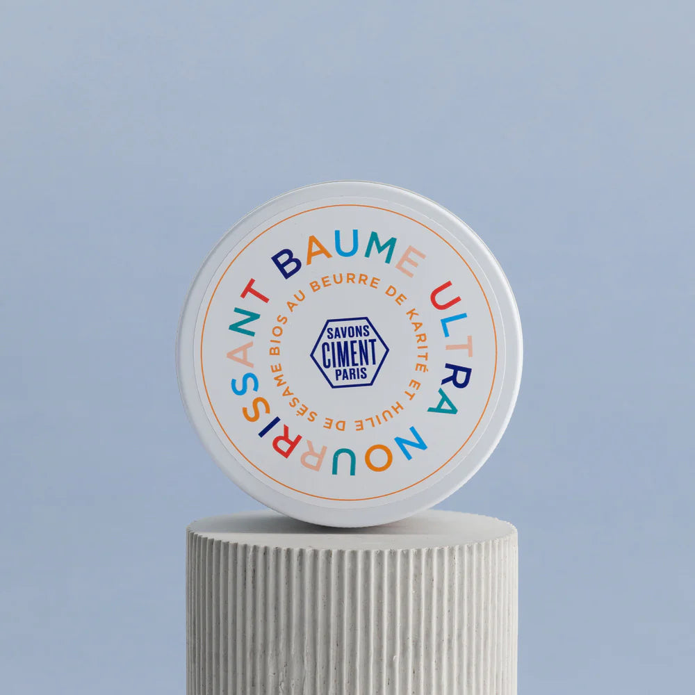 Baume Ultra Nourrissant de Ciment Paris sobre pedestal. Bálsamo corporal con 75 % de karité para piel suave y elástica.