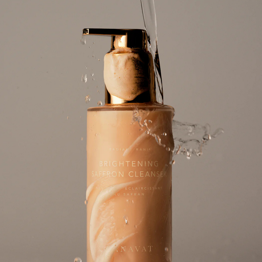 Espuma ligera emergiendo del dosificador con agua en movimiento, textura que limpia sin resecar la piel.