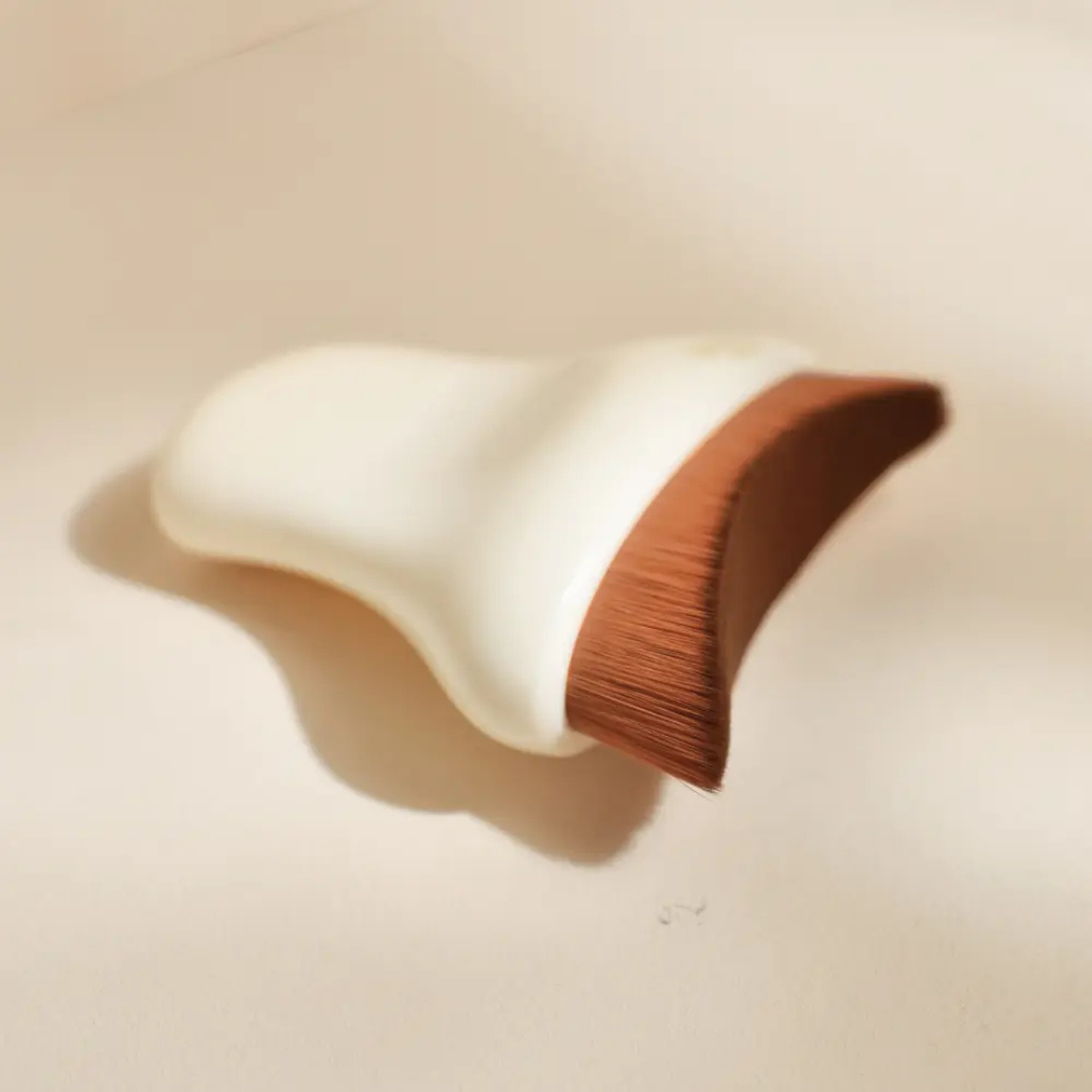 Diseño curvado y cerdas flexibles pensado para acompañar el drenaje facial diario.