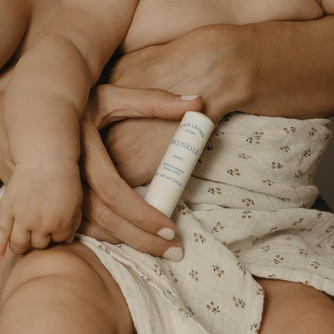 Mami con sentado en su regazo con el Lip Stick de Minois, un gesto sencillo para calmar labios secos sin complicaciones.